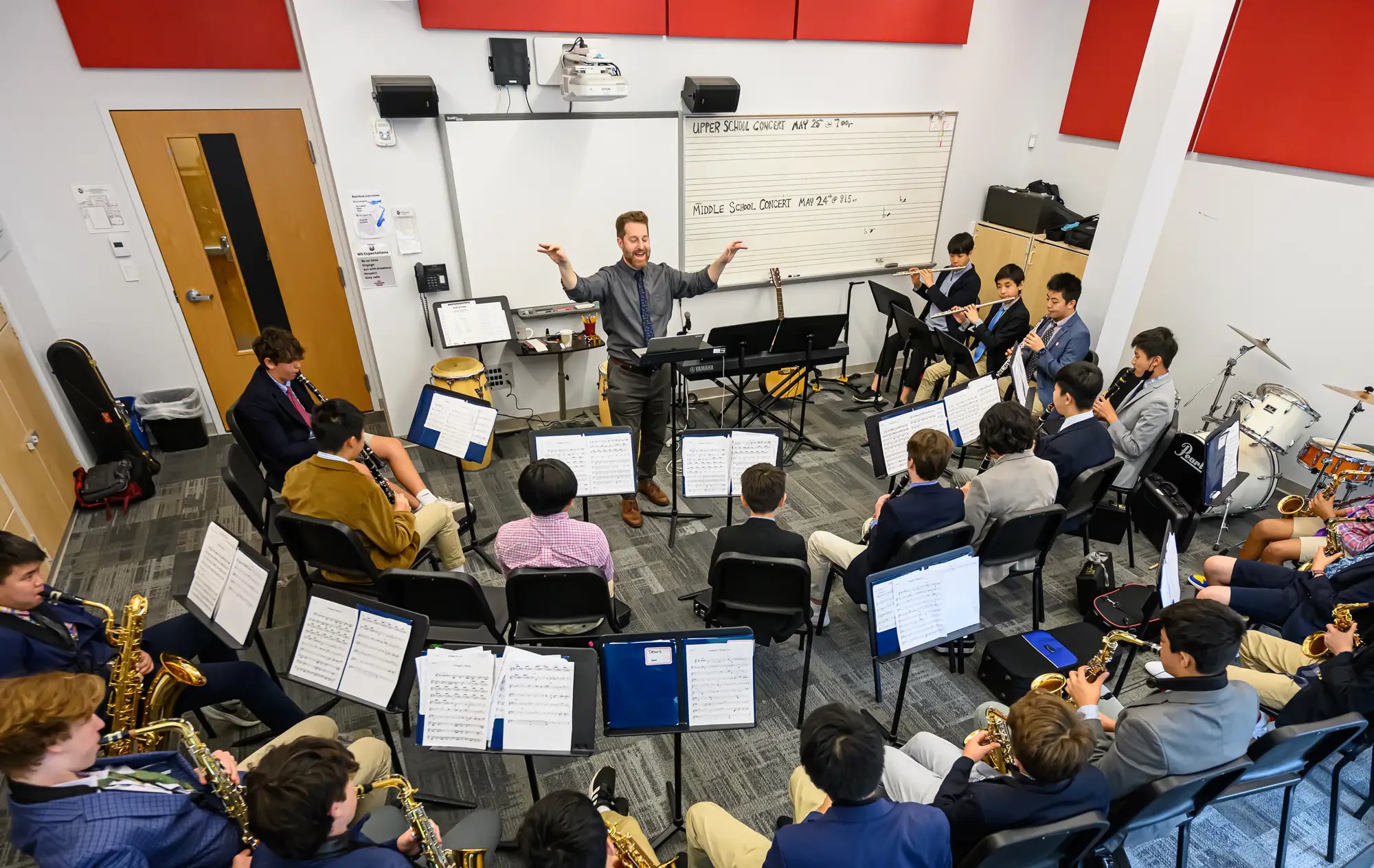Чоловік-диригент керує невеликою групою учнів середньої школи