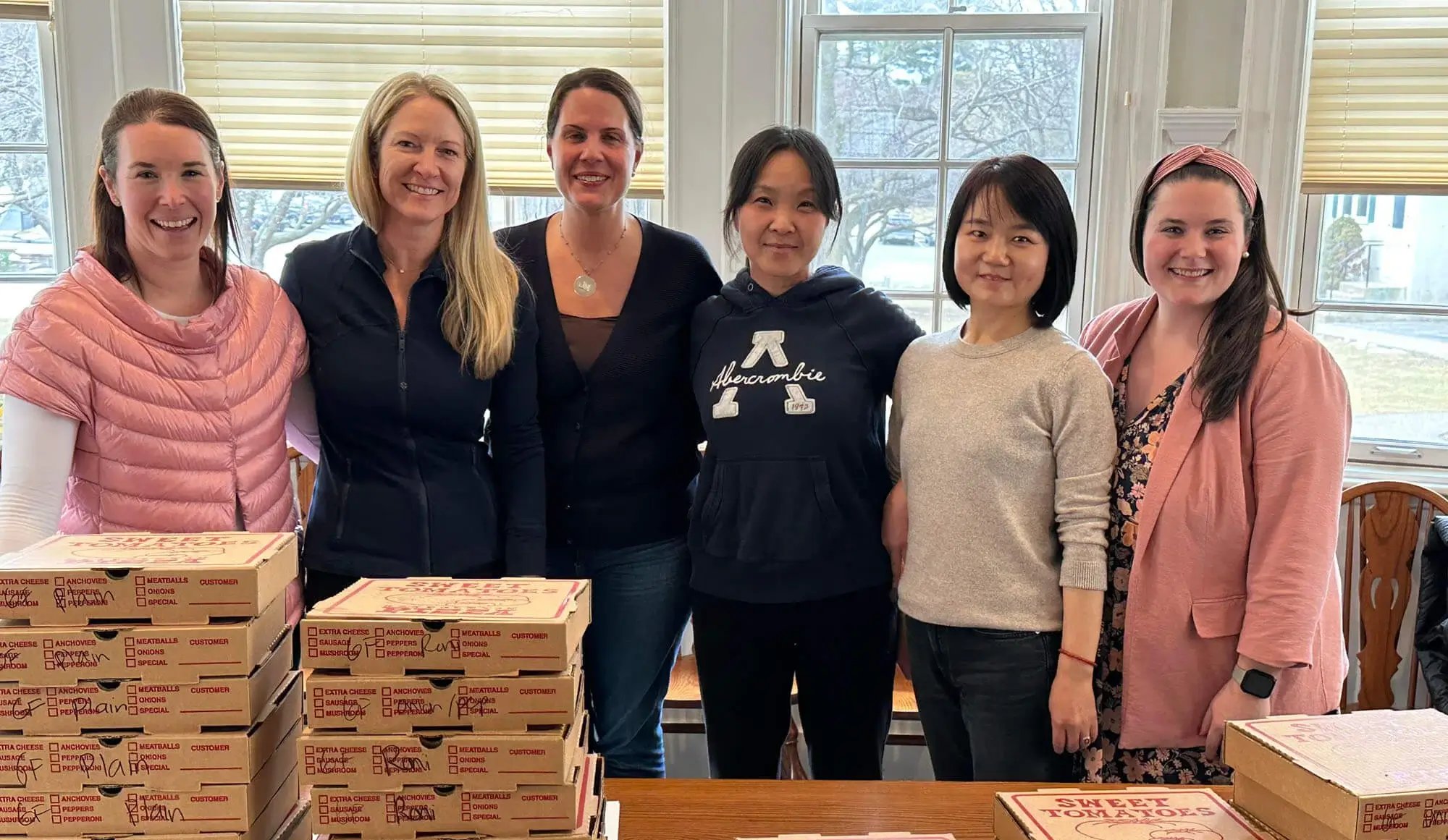 Вдячність викладацького складу - жінки, що стоять за коробками з піцою